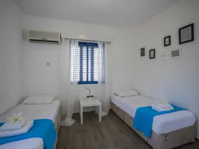 two beds in a room with a window at Protaras Villa Stef in Protaras