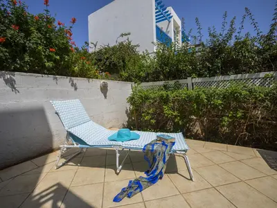a blue chair and a table on a patio at Protaras Villa Stef in Protaras