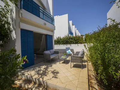 a patio with chairs and a table next to a building at Protaras Villa Stef in Protaras