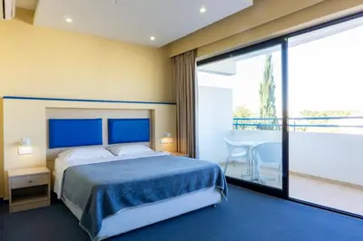 a bedroom with a bed and a large window at Mariandy Hotel in Larnaka