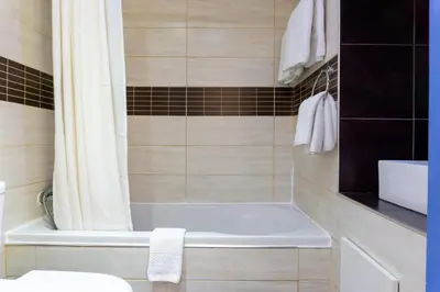 a bathroom with a white tub and a shower at Mariandy Hotel in Larnaka
