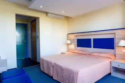 a bedroom with a large bed and blue carpet at Mariandy Hotel in Larnaka