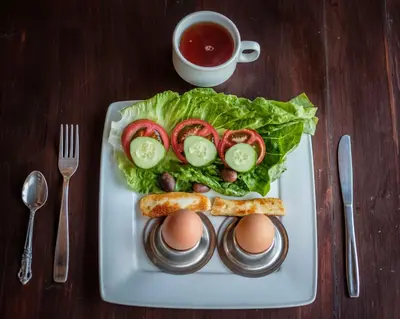 a plate of food with eggs and lettuce and tomatoes at Teacher's House in Maroni