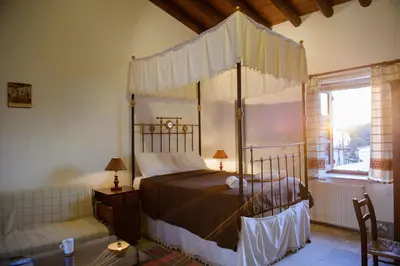 a bedroom with a canopy bed and a couch at Teacher's House in Maroni