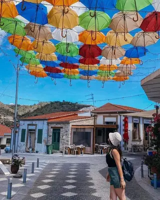 a woman standing under a bunch of colorful umbrellas at Kalavasos View Traditional Apartments in Kalavasos