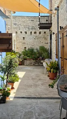 a patio with tables and chairs and plants at Kozakos Luxury House in Pano Lefkara