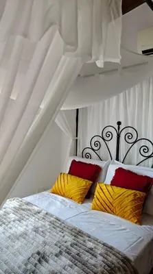 a bedroom with a bed with yellow and red pillows at Kozakos Luxury House in Pano Lefkara