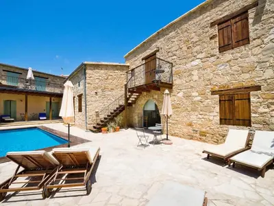 an outdoor patio with chairs and a swimming pool at Evkarpos Country House in Psematismenos