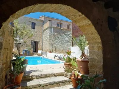 an archway leading to a swimming pool with potted plants at Vrakas House in Tochni