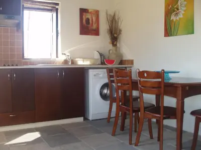 a kitchen with a table and chairs and a dishwasher at Vrakas House in Tochni