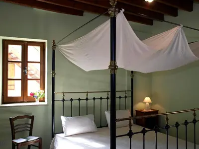 a bedroom with a canopy bed and a window at Porfyrios Country House in Chirokitia