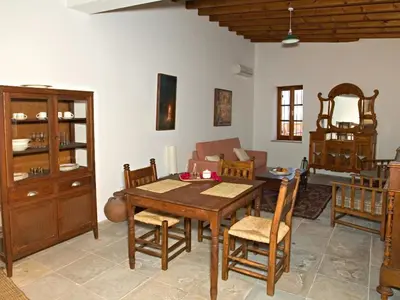 a living room with a wooden table and chairs at Porfyrios Country House in Chirokitia