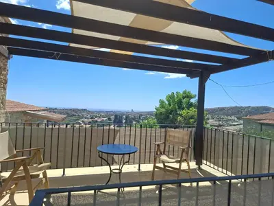 a patio with a table and chairs on a balcony at Kleanthis House in Tochni