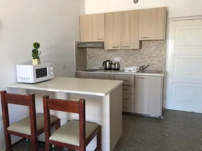 a kitchen with a counter with two chairs and a microwave at Kasapis Apts in Larnaka