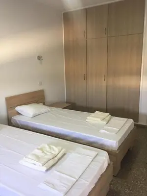 two beds with white sheets in a room at Kasapis Apts in Larnaka