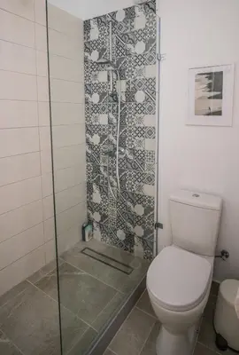 a bathroom with a toilet and a glass shower at Anemomylos guesthouse in Paralimni