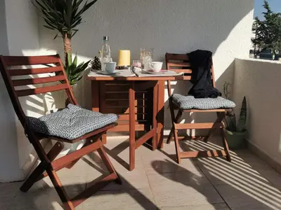 a table and two chairs on a balcony with a table and chairs at Anemomylos guesthouse in Paralimni