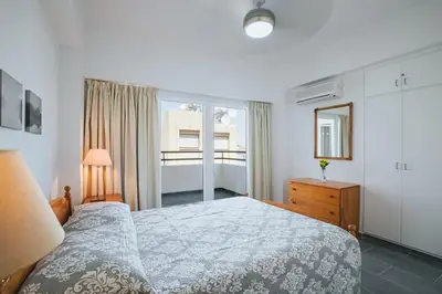 a bedroom with a bed and a dresser and a window at Lazaros Centre Apartment in Larnaka