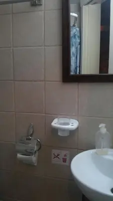 a bathroom with a sink and a mirror at Eleni's Cottage in Apsiou