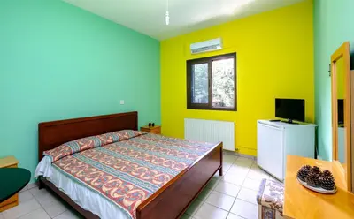 a bedroom with yellow and blue walls and a bed at Platres Valley Houses in Platres