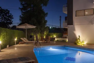 a swimming pool in the backyard of a house at night at The Jolo in Limassol