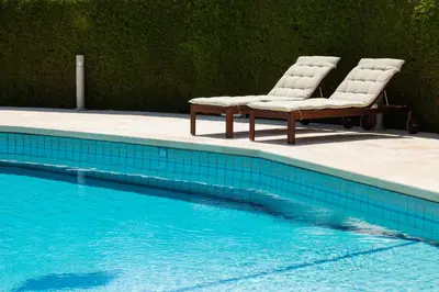 two chairs sitting next to a swimming pool at The Jolo in Limassol