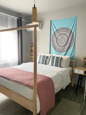 a bedroom with a bed with a poster on the wall at Cheerful Apartment in Nicosia in Yukarı Lakatamya
