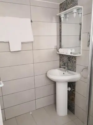 a white bathroom with a sink and a mirror at Cheerful Apartment in Nicosia in Yukarı Lakatamya