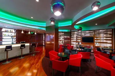 a restaurant with red chairs and a bar at Melissi Beach Hotel & Spa in Ayia Napa