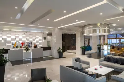 a lobby with couches and tables in a building at Melissi Beach Hotel & Spa in Ayia Napa