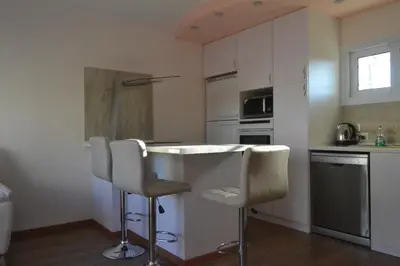 a kitchen with a counter and two bar stools at Двуспальная квартира возле дасуди in Limassol