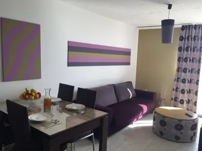 a living room with a table and a purple couch at Agrino Hotel Apartments in Ayia Napa