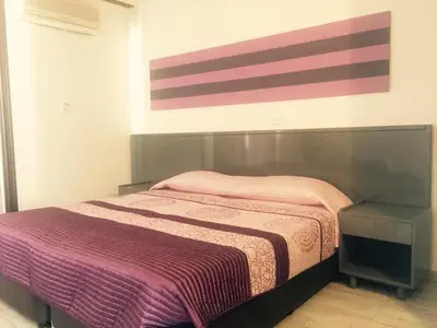 a bedroom with a bed and a painting on the wall at Agrino Hotel Apartments in Ayia Napa