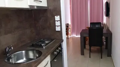 a kitchen with a sink and a stove and a table at Agrino Hotel Apartments in Ayia Napa
