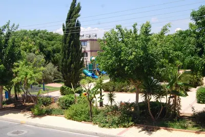 a park with trees and a playground with a slide at Agrino Hotel Apartments in Ayia Napa