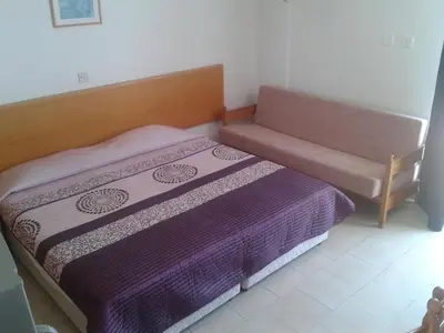 a small bedroom with a bed and a couch at Agrino Hotel Apartments in Ayia Napa