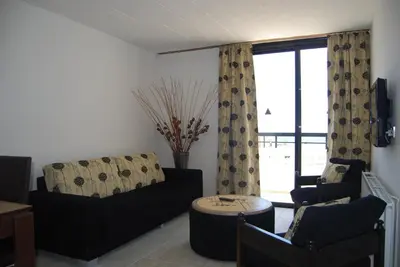 a living room with a couch and chairs and a window at Agrino Hotel Apartments in Ayia Napa