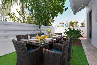 a dining table and chairs on a patio at Villa Calliopi in Protaras