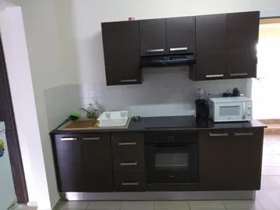 a kitchen with dark brown cabinets and a microwave at Hermes complex1 paralimni in Paralimni