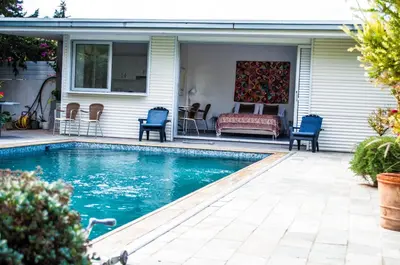 a swimming pool with chairs and a couch on a house at Idyllic studio with private pool in Nicosia