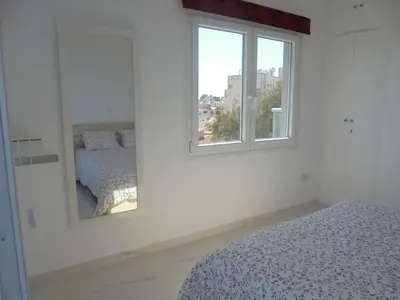 a white room with a bed and a mirror at Kermia Court - Beach-front, modern 2 bedroom -sleeps 6 in Limassol