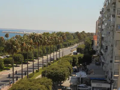 a city street with palm trees and a building at Kermia Court - Beach-front, modern 2 bedroom -sleeps 6 in Limassol