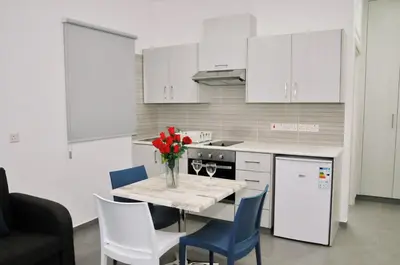 a kitchen with a table with a vase of flowers on it at Kaos Hotel Apartments in Ayia Napa