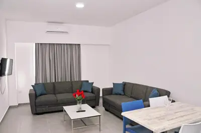 a living room with two couches and a table at Kaos Hotel Apartments in Ayia Napa