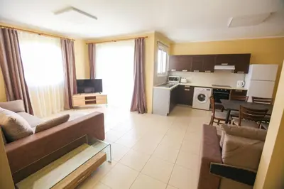 a large living room with a couch and a kitchen at Carisa Livadia Gardens in Livadhia
