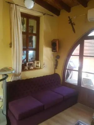 a living room with a purple couch in front of a window at Petro's Antique House in Nicosia