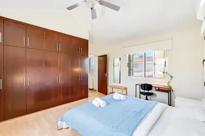 a bedroom with a blue bed and wooden cabinets at Villa Venus by Ezoria Villas in Pervolia