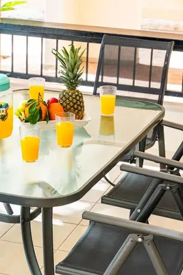 a table with a plate of fruit and orange juice at Villa Venus by Ezoria Villas in Pervolia