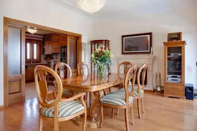 a dining room table with chairs and a vase of flowers at Limassol Beachfront Holiday Villa in Limassol