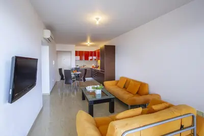 a living room with two couches and a table at one bedroom apartment in Fig tree bay in Protaras